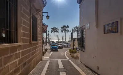 a car driving down a street with palm trees at Hola Sitges Apartments in Sitges