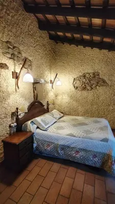 a bedroom with a bed and two lights on the wall at Masia Can Felip B&B in Llinars del Vallès