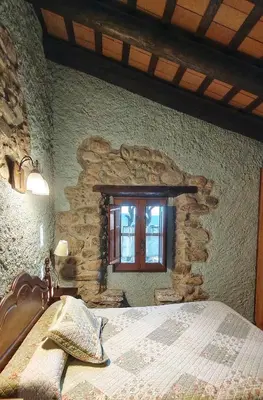 a bedroom with a bed in a stone wall at Masia Can Felip B&B in Llinars del Vallès