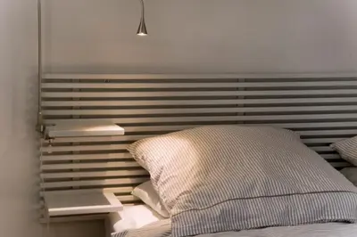 a bed with a wooden headboard with a pillow at Montaber Apartment - Bailén in Barcelona