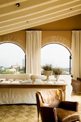 a living room with a table and two windows at Can Mora de Dalt in Sant Vicenç de Montalt