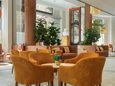 a lobby with chairs and a table and a couch at H10 Casanova in Barcelona