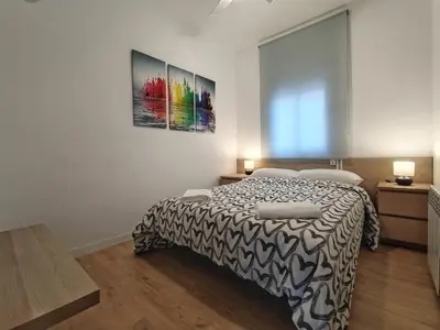 a bedroom with a bed with a black and white blanket at LG DownTown Sabadell Apartment in Sabadell