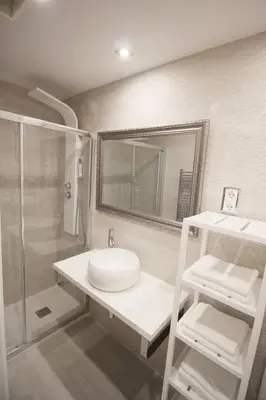 a bathroom with a sink and a shower and a mirror at Family Deluxe Apartment Beach in Castelldefels