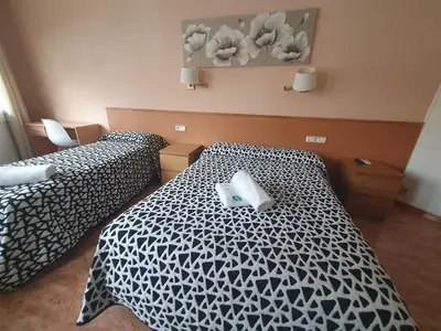 a hotel room with two beds with black and white sheets at Hostal Rio De Castro in Barcelona