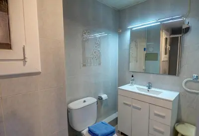 a bathroom with a toilet and a sink and a mirror at The Moon Studio by Hello Homes Sitges in Sitges