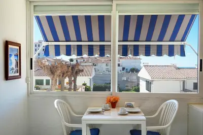 a table and chairs in a room with a window at The Moon Studio by Hello Homes Sitges in Sitges