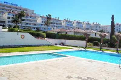 a swimming pool in front of a large building at The Moon Studio by Hello Homes Sitges in Sitges