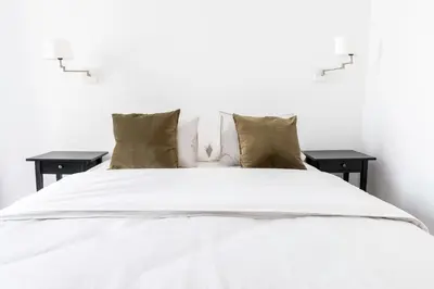 a bedroom with a white bed with two tables at B-Garden BCN in Barcelona