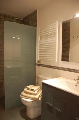 a bathroom with a toilet and a sink and a mirror at Montseny Suites & Apartments in Montseny