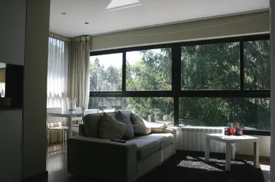 a living room with a couch and a large window at Montseny Suites & Apartments in Montseny