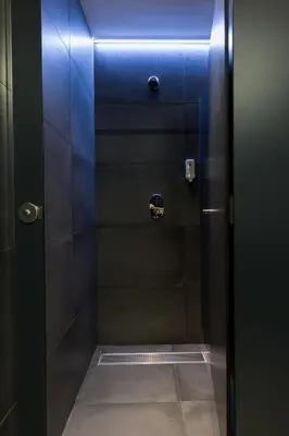 a shower with a blue light in a bathroom at Airhostel Barcelona Airport 24h in El Prat de Llobregat