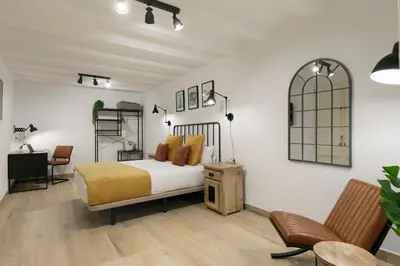 a bedroom with a bed and a desk and a chair at KeyFamily Loft Las Ramblas in Barcelona