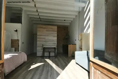 a room with a bed and a table and a chair at apartamento en el centro in Vilanova i la Geltrú