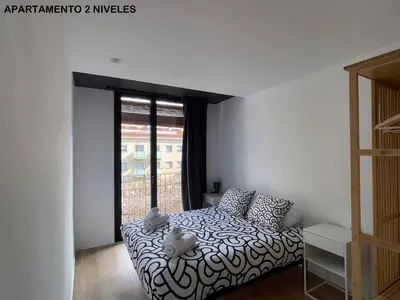 a bedroom with a bed and a large window at apartamento en el centro in Vilanova i la Geltrú