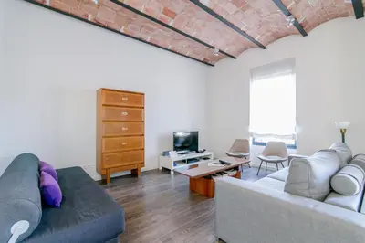 a living room with a couch and a tv at Decô Apartments Barcelona-Diagonal in Barcelona