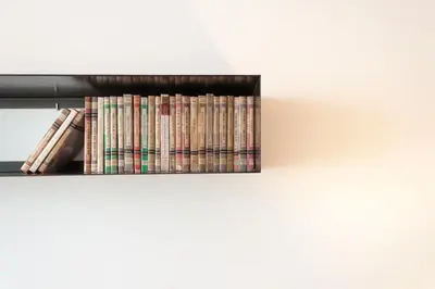 a stack of books sitting on a shelf at Decô Apartments Barcelona-Diagonal in Barcelona