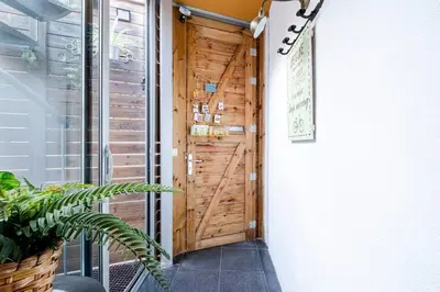 a wooden door in a hallway with a plant at Terrassa de Mar Apartment in Masnou