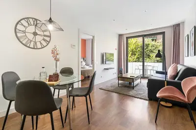 a living room with a table and chairs and a clock at Sensation Sagrada Familia in Barcelona