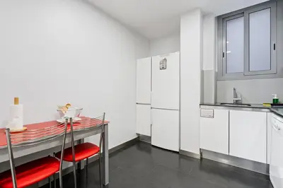 a kitchen with a table and a red stool at Sensation Sagrada Familia in Barcelona
