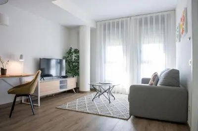 a living room with a couch and a tv at Aura Park Aparthotel Fira Barcelona in Hospitalet de Llobregat