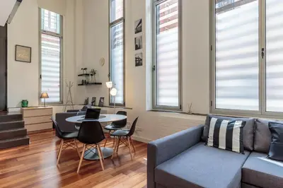 a living room with a couch and a table with chairs at Modern and Trendy Duplex next to Paseo de Gracia in Barcelona
