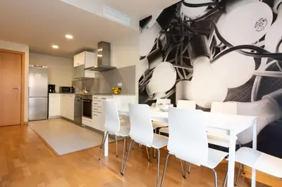 a kitchen with a dining table and white chairs at AB Park Güell-Gaudi in Barcelona