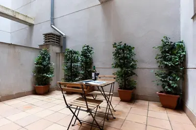 a patio with a table and potted plants at AB Park Güell-Gaudi in Barcelona