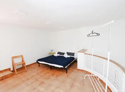 a room with a bed sitting on a wooden floor at La casa del Pi · La casa del Pi · House in the city, next to Barcelona and beach in Badalona