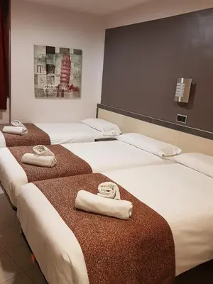 a room with three beds with folded towels on them at Hostal Levante Barcelona in Barcelona