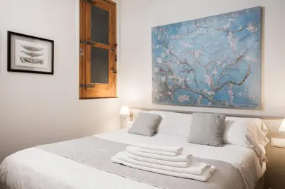 a bedroom with a white bed with towels on it at BCN Rambla Catalunya Apartments in Barcelona