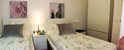 a small bedroom with two beds and a night stand at Sitges Apartment in Sitges