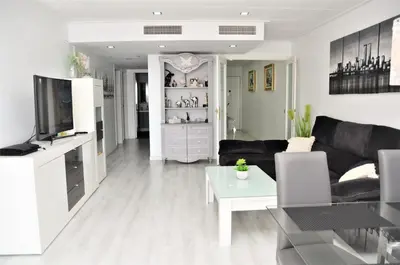 a living room with a black couch and a table at fantasticas vistas a mar in Pineda de Mar
