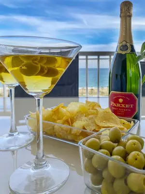 a table with two glasses of wine and a plate of food at fantasticas vistas a mar in Pineda de Mar