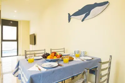 a table with a blue table cloth and a bowl of fruit at Heart of Sitges in Sitges