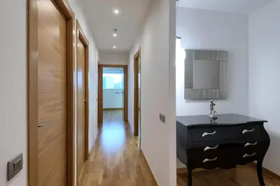 a hallway with a black dresser next to a door at Plaza Europa Fira Gran Via in Hospitalet de Llobregat
