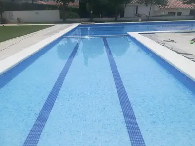a large blue swimming pool with blue water at Sitges - Apartamento in Sitges