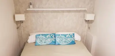 two blue pillows sitting on top of a bed at Sitges - Apartamento in Sitges