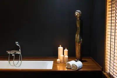 a bathroom with a bath tub with candles and a statue at Primero Primera in Barcelona