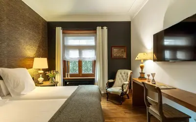 a bedroom with a bed and a desk and a window at Primero Primera in Barcelona