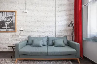 a blue couch in a room with a brick wall at Stylish Apartment with Terrace for Couple or Family in Barcelona