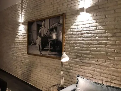 a brick wall with a lamp and a picture on it at Stylish Apartment with Terrace for Couple or Family in Barcelona