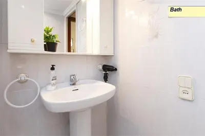 a white bathroom with a sink and a mirror at Apartamento Joel in Barcelona
