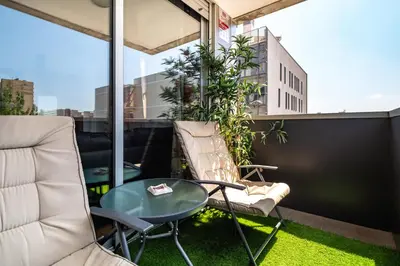 a balcony with a glass table and chairs at Forum Beach in Sant Adria de Besos