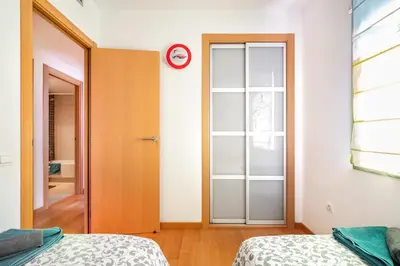 a bedroom with two beds and a clock on the wall at Forum Beach in Sant Adria de Besos