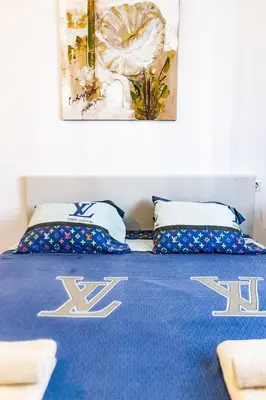 a bedroom with a blue bed with two pillows at Forum Beach in Sant Adria de Besos