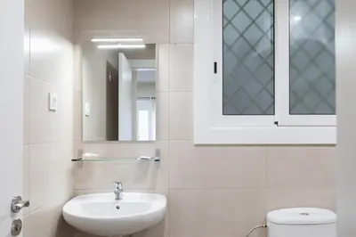 a bathroom with a sink and a toilet and a mirror at Hostal Oliveta in Barcelona