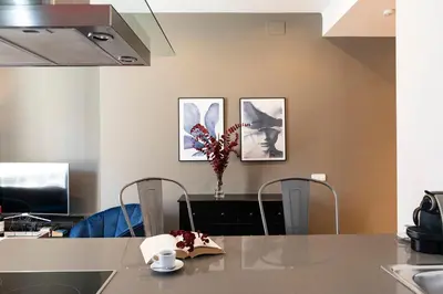 a kitchen with a table and three pictures on the wall at Central Suites Barcelona in Barcelona
