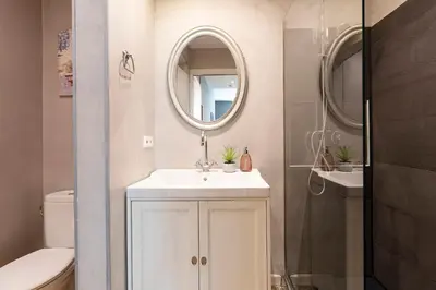 a white bathroom with a sink and a mirror at Central Suites Barcelona in Barcelona