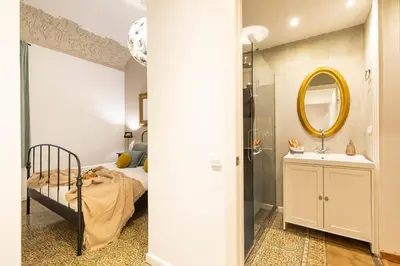 a bedroom with a bed and a sink and a mirror at Central Suites Barcelona in Barcelona